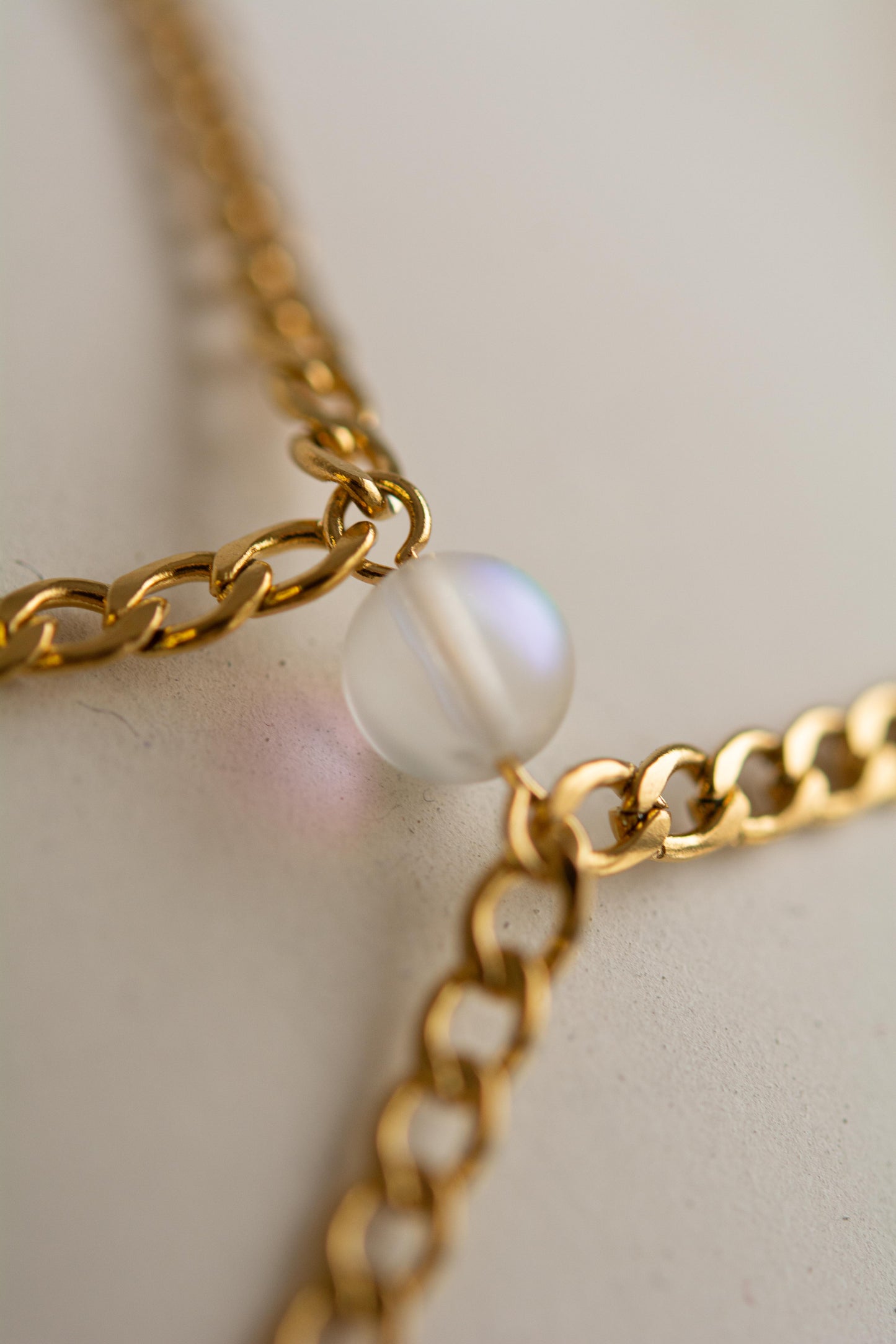 Top tour de cou en acier inoxydable plaqué or avec chaînes et perles holographiques.