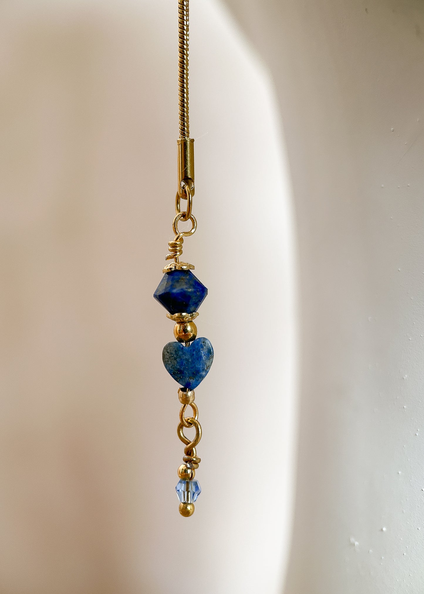 Chaîne de visage fluide en acier inoxydable plaqué or avec véritable lapis-lazuli. Bijou facial bleu et or de style égyptien, fait main à Montréal.