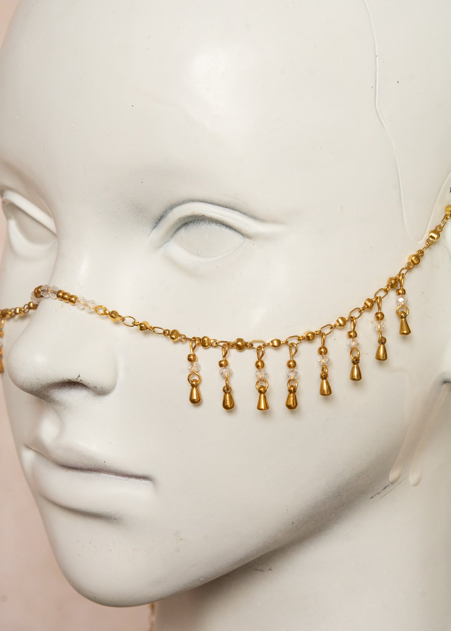 Chaîne de visage dorée avec cristaux translucides, billes dorées et breloques gouttes. Bijou unisexe raffiné, inspiration orientale, idéal pour festivals, scène, costumes, etc.