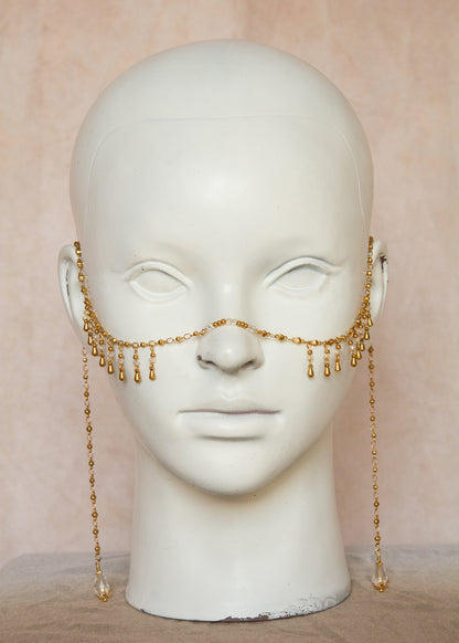 Chaîne de visage dorée avec cristaux translucides, billes dorées et breloques gouttes. Bijou unisexe raffiné, inspiration orientale, idéal pour festivals, scène, costumes, etc.