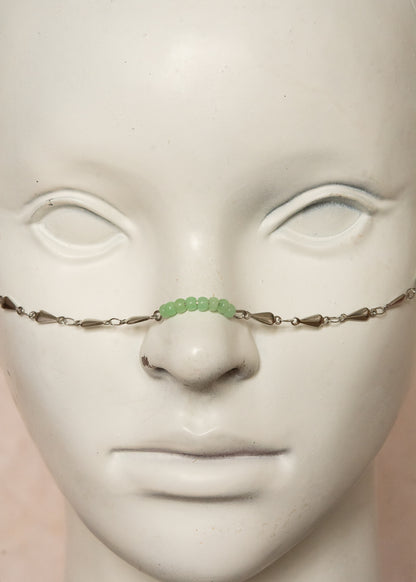 Chaîne de visage unisexe en acier argenté, avec jade verte sur le nez et aux extrémités. Bijou fluide et mystique, inspiré des divinités serpentines.