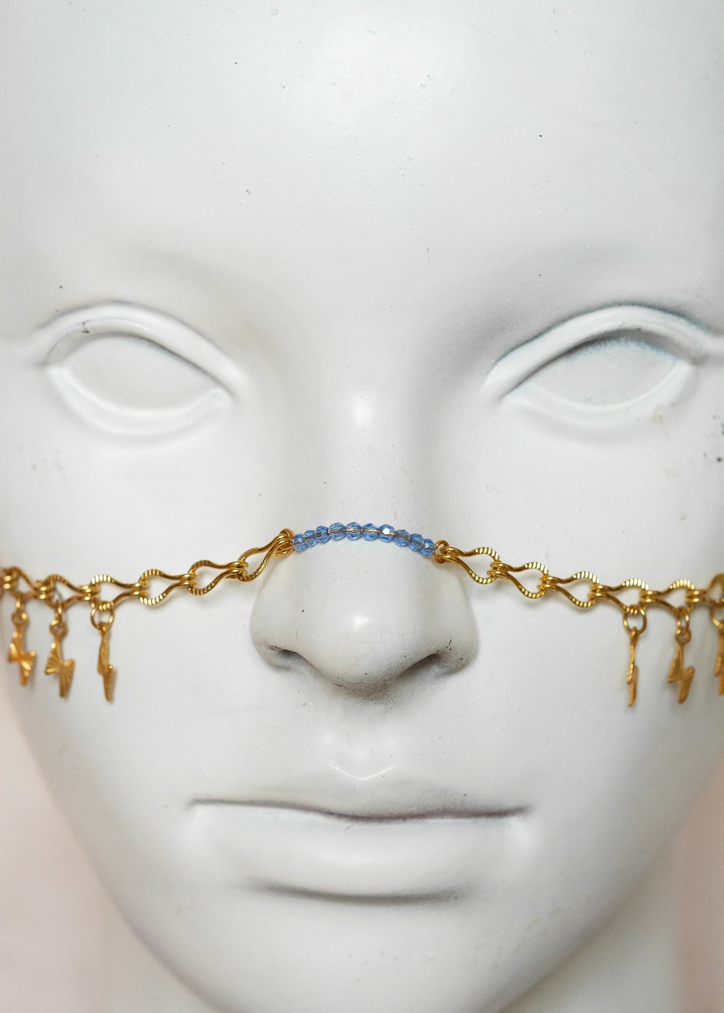 Chaîne de visage en acier inoxydable doré, éclairs dorés, cristaux bleus et perles goutte bleue. Bijou festival ou cosplay mythologie grecque.