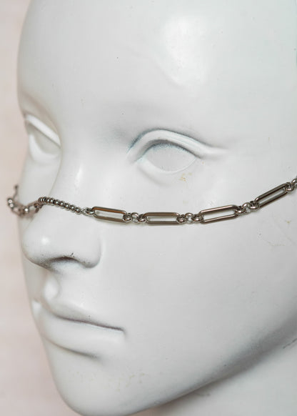 Chaîne de visage en acier inoxydable argenté, maillage géométrique, billes d’acier et pierres de lave. Bijou guerrier et audacieux.