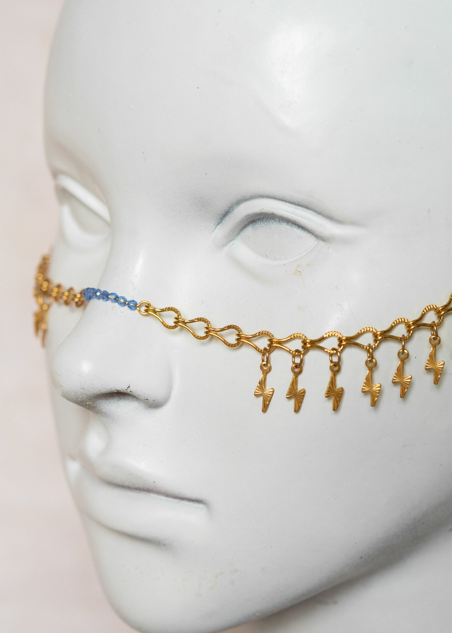 Chaîne de visage en acier inoxydable doré, éclairs dorés, cristaux bleus et perles goutte bleue. Bijou festival ou cosplay mythologie grecque.
