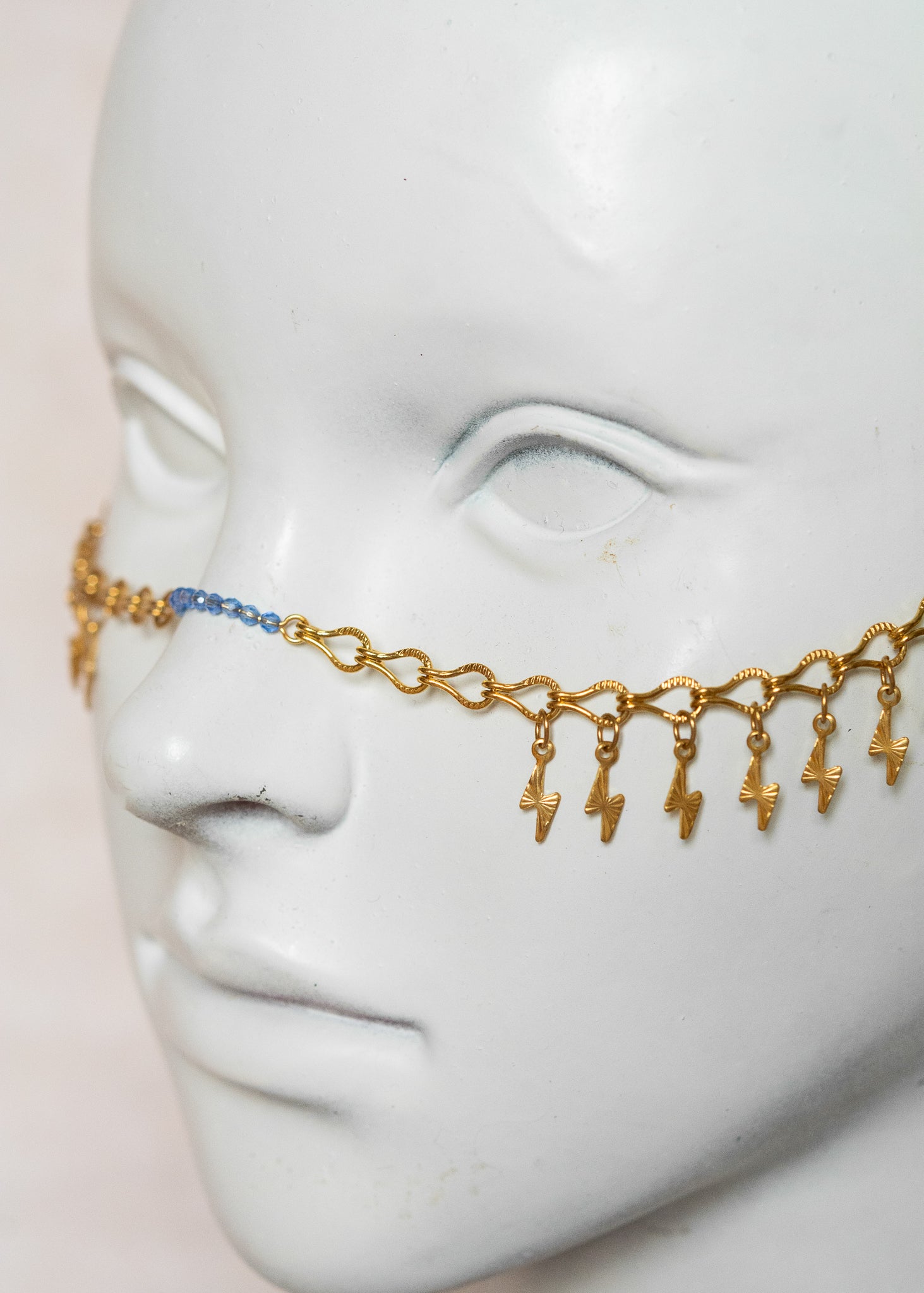 Chaîne de visage en acier inoxydable doré, éclairs dorés, cristaux bleus et perles goutte bleue. Bijou festival ou cosplay mythologie grecque.