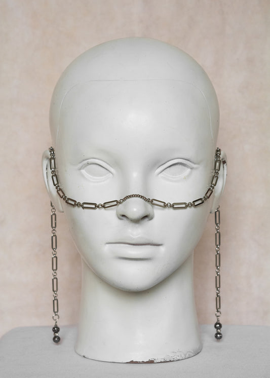 Chaîne de visage en acier inoxydable argenté, maillage géométrique, billes d’acier et pierres de lave. Bijou guerrier et audacieux.