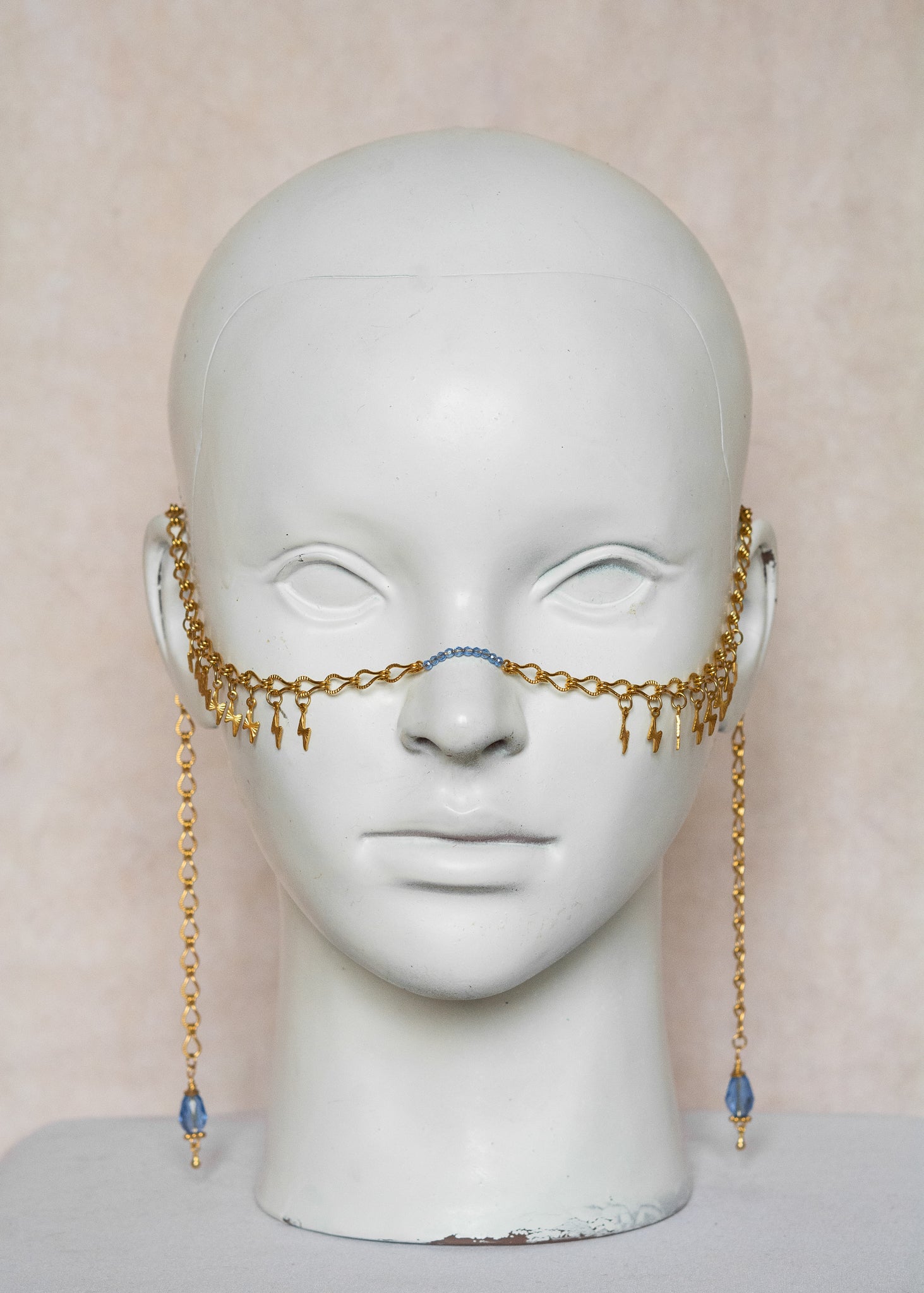 Chaîne de visage en acier inoxydable doré, éclairs dorés, cristaux bleus et perles goutte bleue. Bijou festival ou cosplay mythologie grecque.