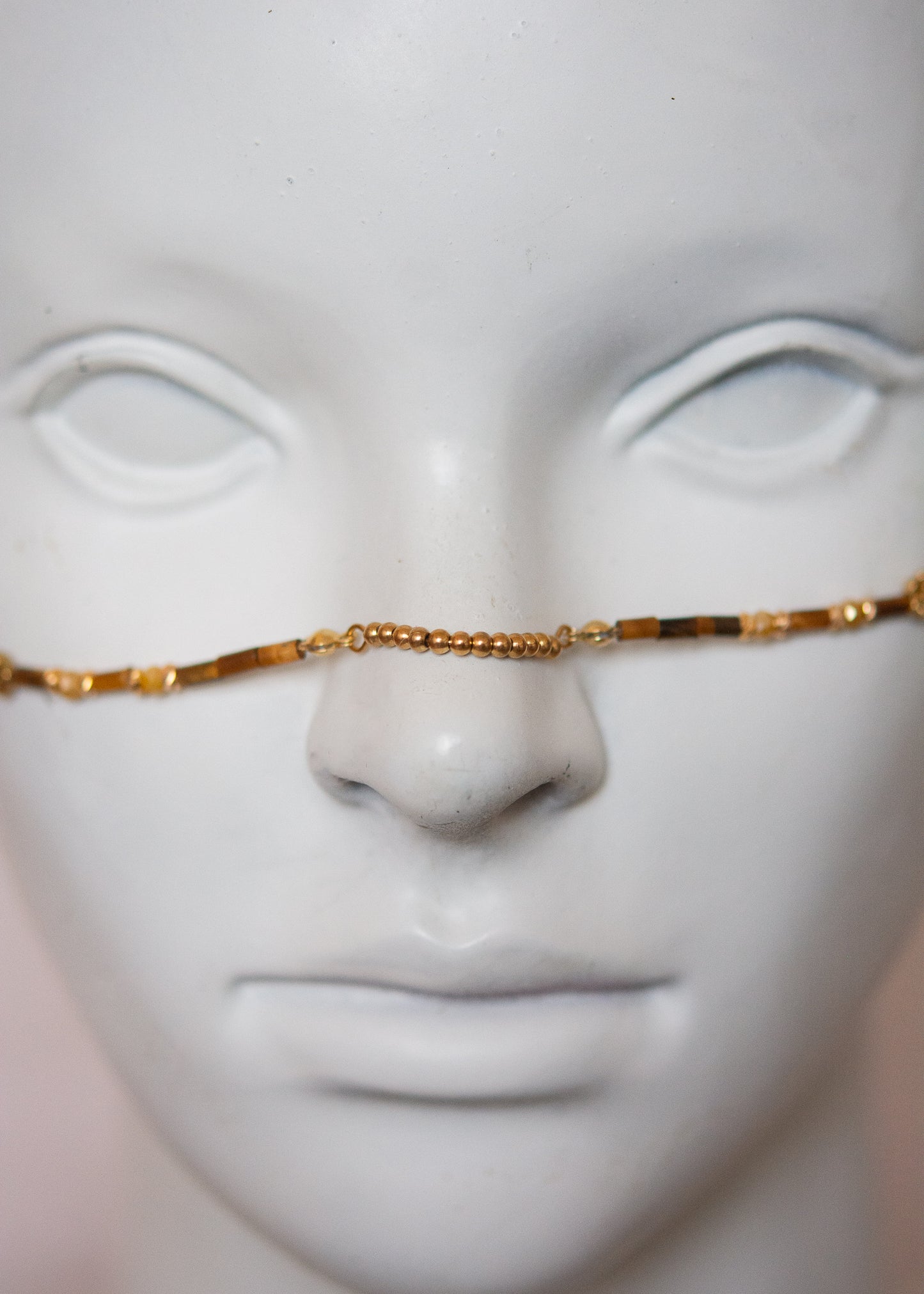 Bijou facial chamanique avec pierre œil de tigre, têtes de taureau et cornes dorées. Accessoire festival, tribal, costume ou photoshoot.