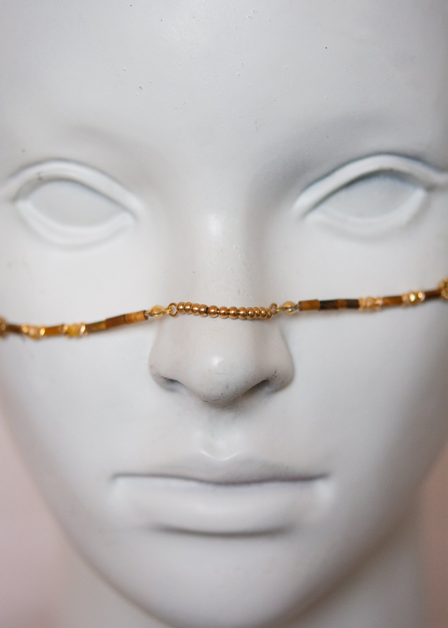 Bijou facial chamanique avec pierre œil de tigre, têtes de taureau et cornes dorées. Accessoire festival, tribal, costume ou photoshoot.