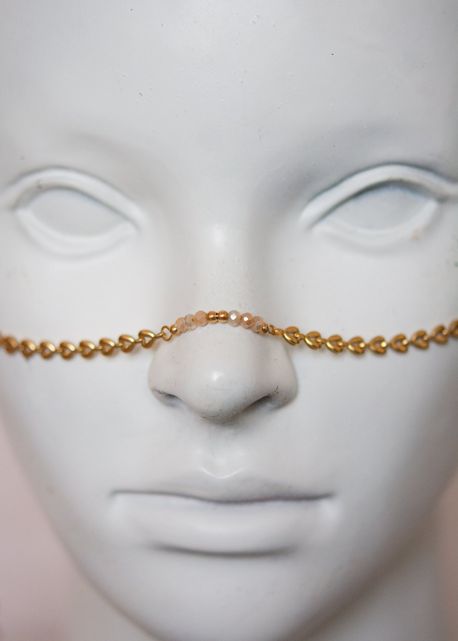 Bijou facial doré avec ambre, cristaux rosés et cornes. Accessoire festival, rituel solaire, costume tribal, photoshoot mystique.