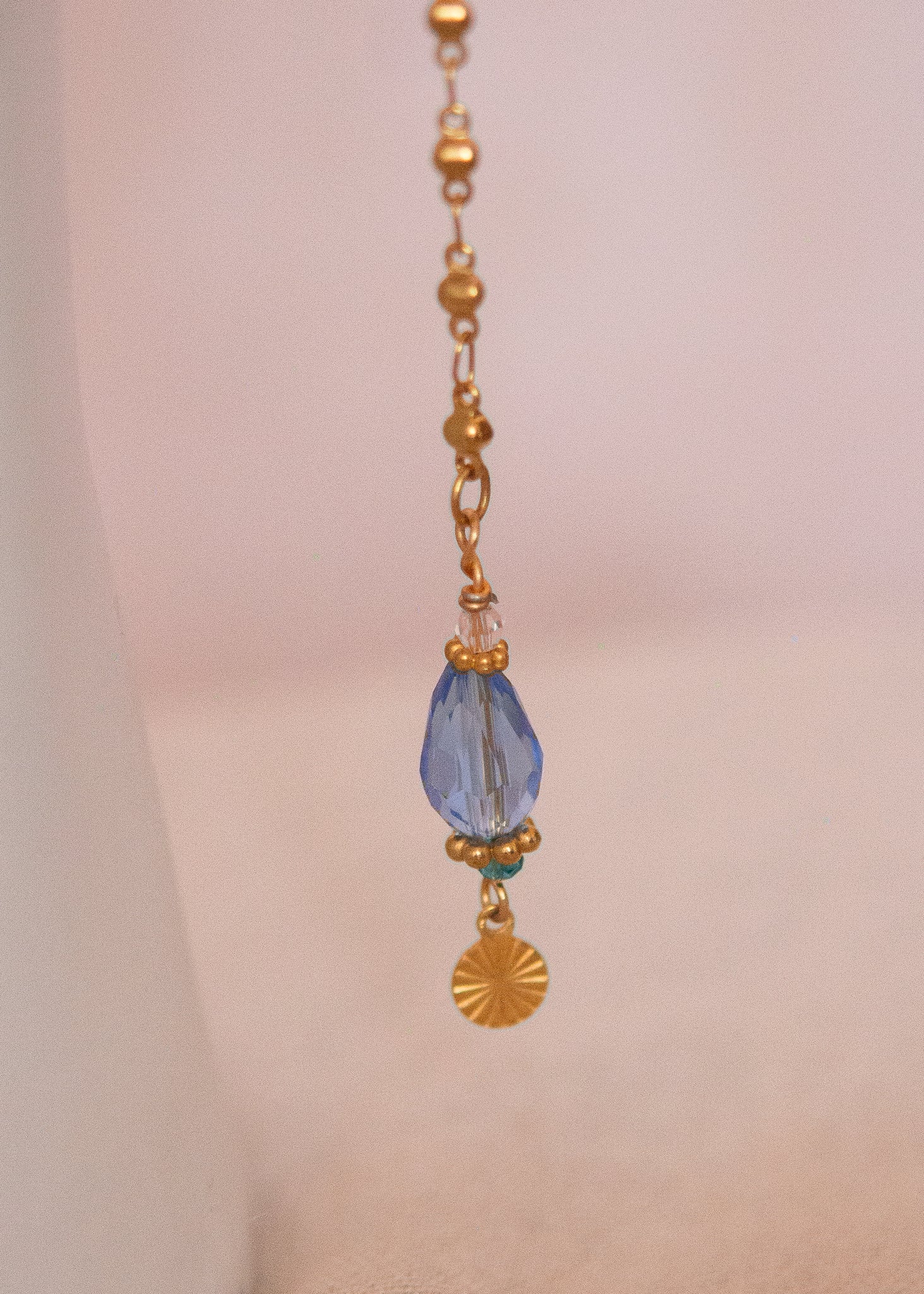 Bijou facial en acier inoxydable doré avec gouttes bleues. Accessoire solaire, pharaonique, festival, costume ou rituel mystique.