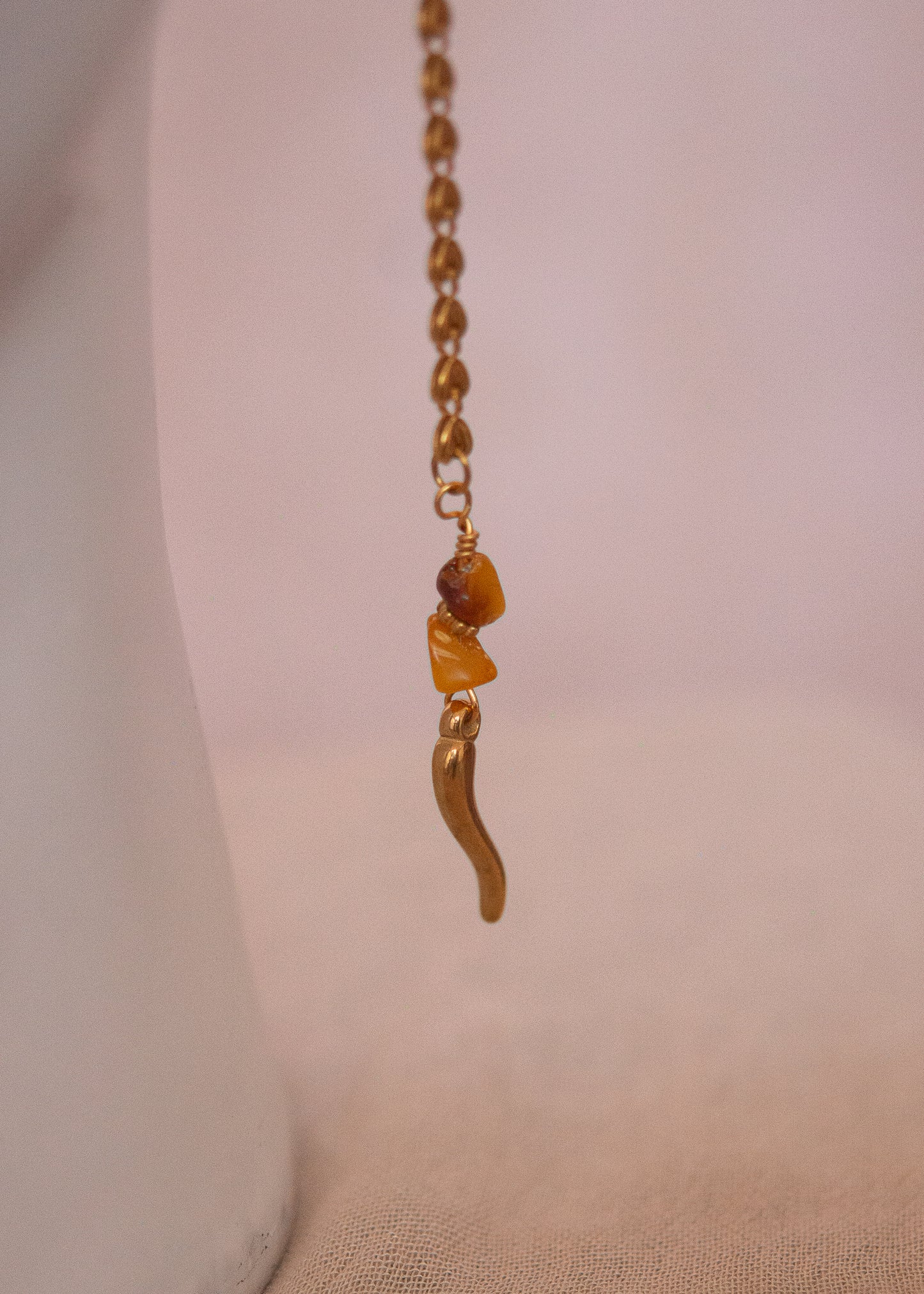 Bijou facial doré avec ambre, cristaux rosés et cornes. Accessoire festival, rituel solaire, costume tribal, photoshoot mystique.