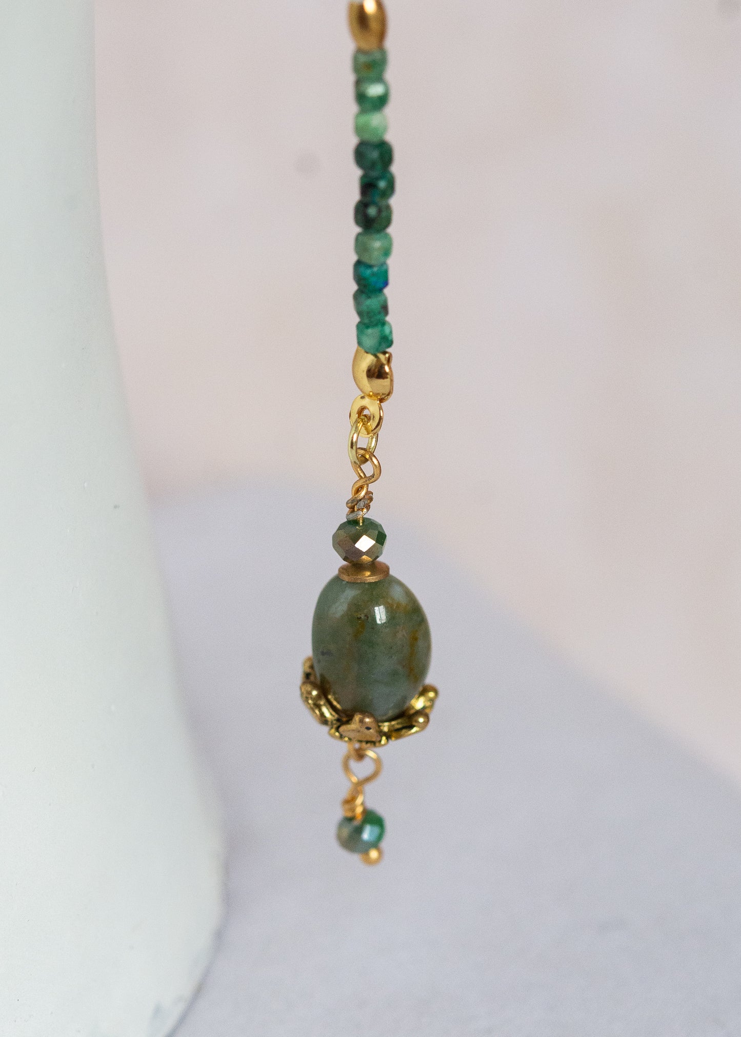 Chaîne de visage avec pierres naturelles de chrysocolla, cristaux verts, détails dorés en acier inoxydable et pierres d’agate indienne | Bijou facial bleu-vert intense | Accessoire de tête artisanal fait main à Montréal | Design structuré et énergique | Pierres fines, éclairs dorés et pont de nez lumineux.