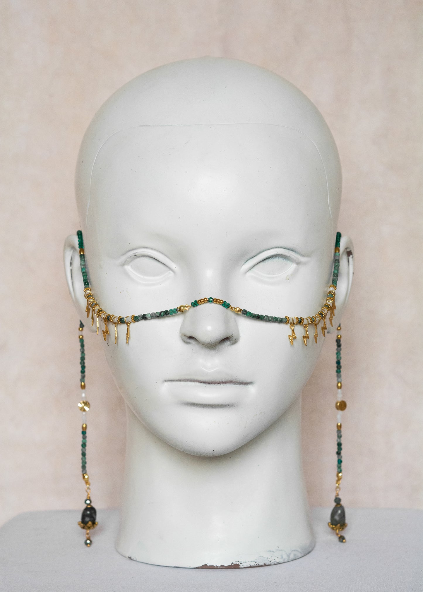 Chaîne de visage avec pierres naturelles de chrysocolla, cristaux verts, détails dorés en acier inoxydable et pierres d’agate indienne | Bijou facial bleu-vert intense | Accessoire de tête artisanal fait main à Montréal | Design structuré et énergique | Pierres fines, éclairs dorés et pont de nez lumineux.