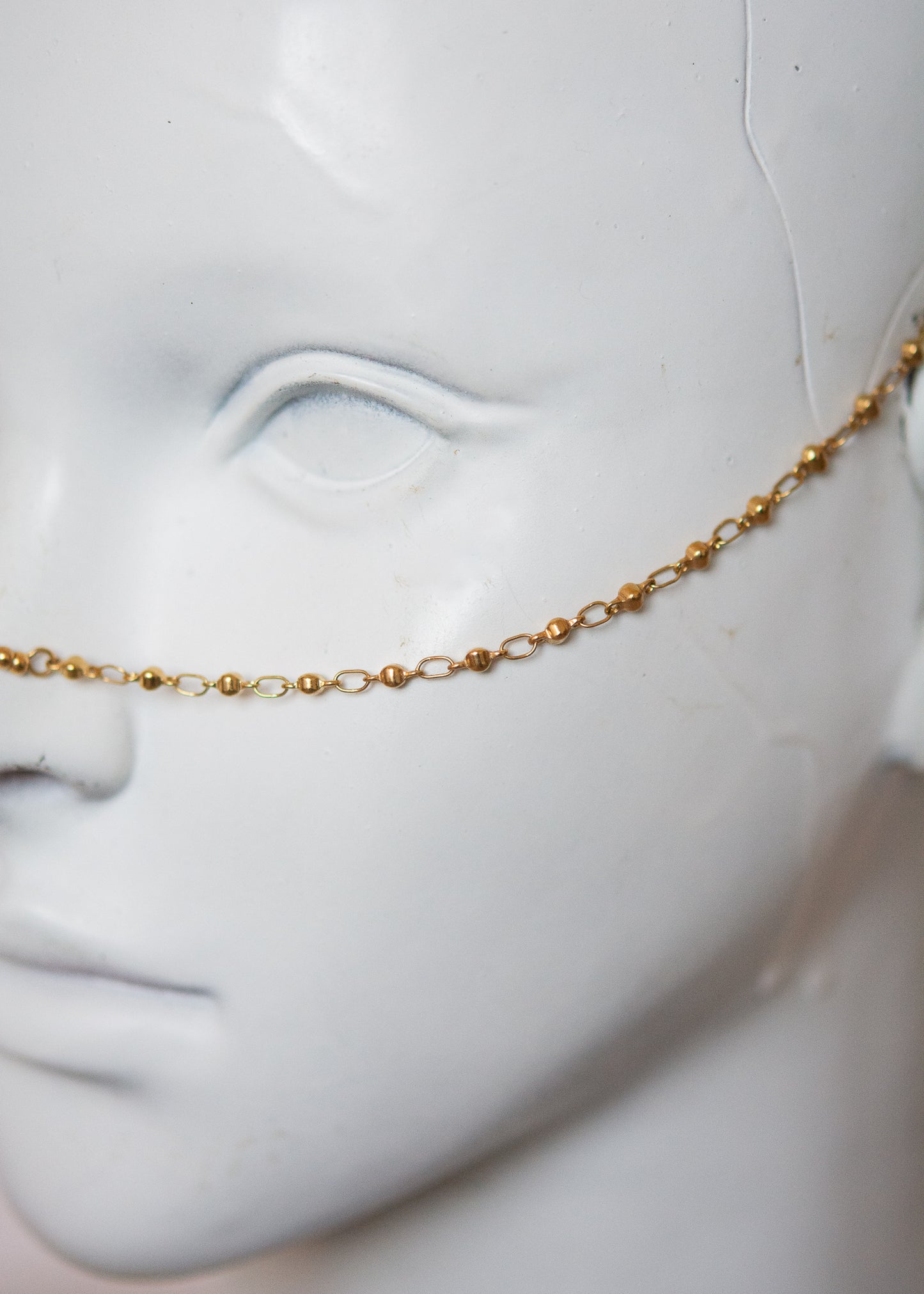 Bijou facial en acier inoxydable doré avec gouttes bleues. Accessoire solaire, pharaonique, festival, costume ou rituel mystique.