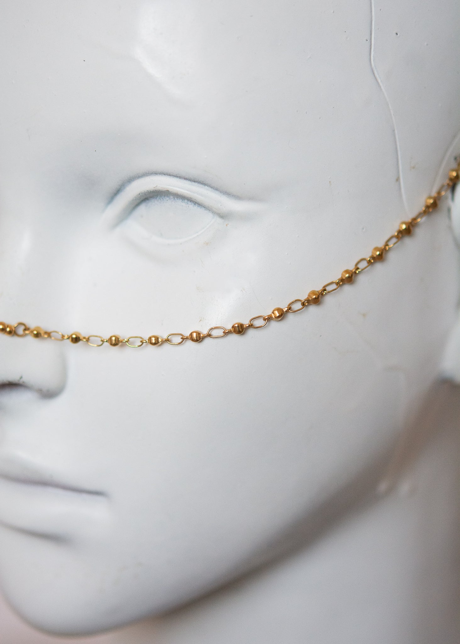 Bijou facial en acier inoxydable doré avec gouttes bleues. Accessoire solaire, pharaonique, festival, costume ou rituel mystique.