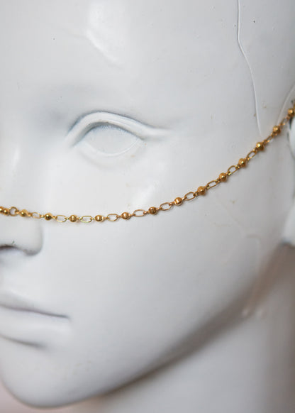 Bijou facial en acier inoxydable doré avec gouttes bleues. Accessoire solaire, pharaonique, festival, costume ou rituel mystique.