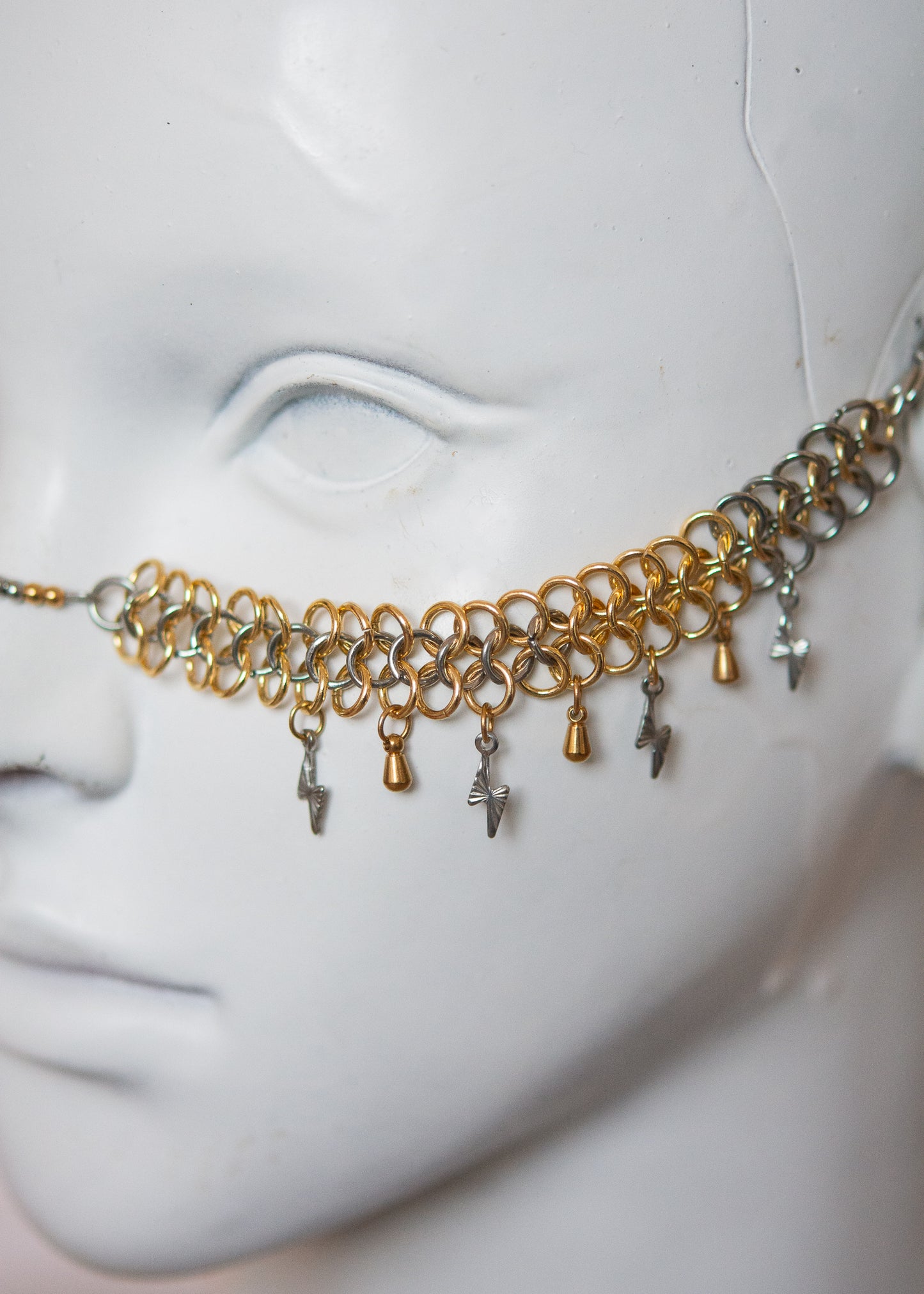Bijou facial acier inoxydable or et argent, motif chainmail, gouttes dorées et éclairs argentés. Accessoire rituel, shoot mystique, festival ou costume stylisé.