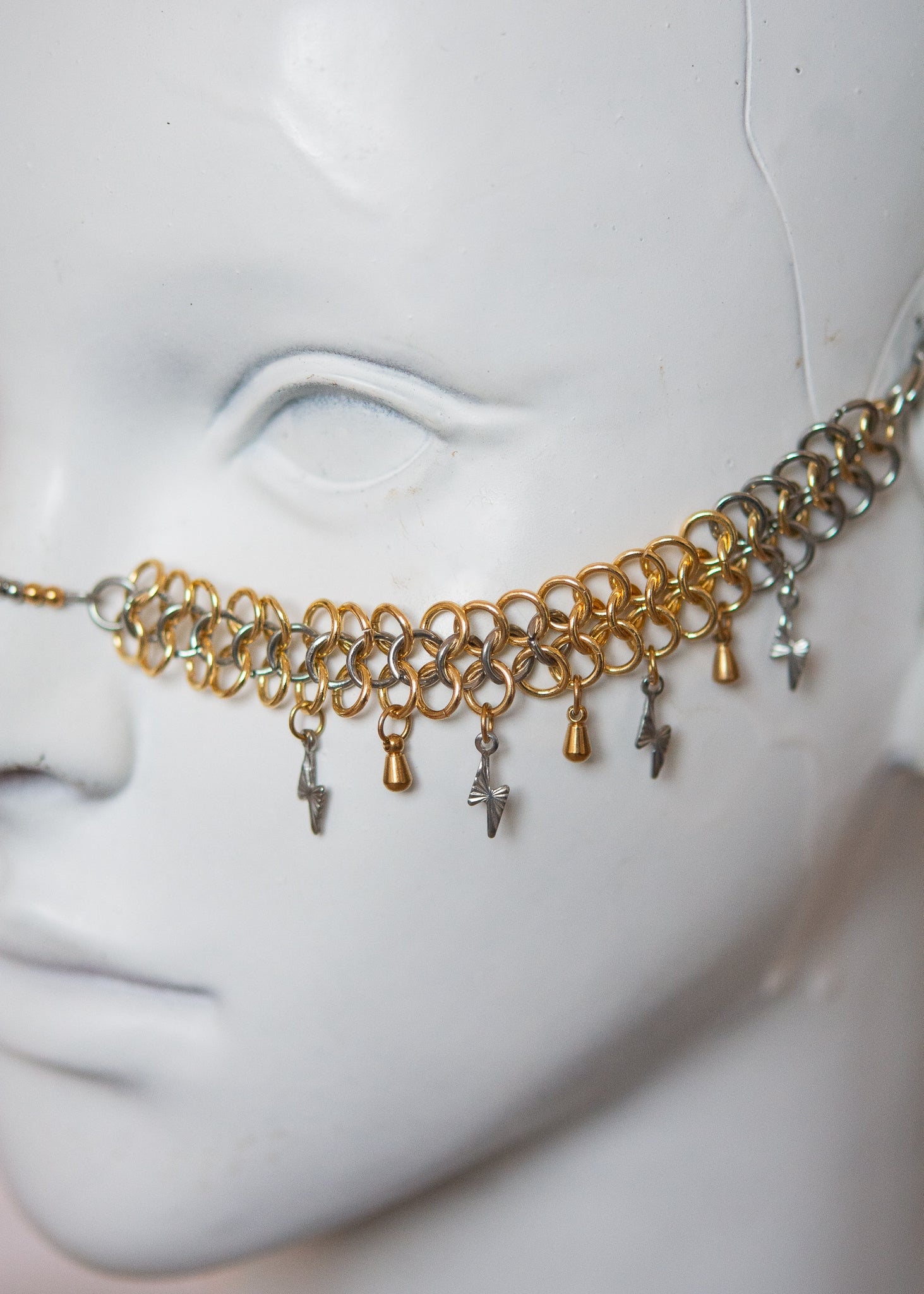 Bijou facial acier inoxydable or et argent, motif chainmail, gouttes dorées et éclairs argentés. Accessoire rituel, shoot mystique, festival ou costume stylisé.