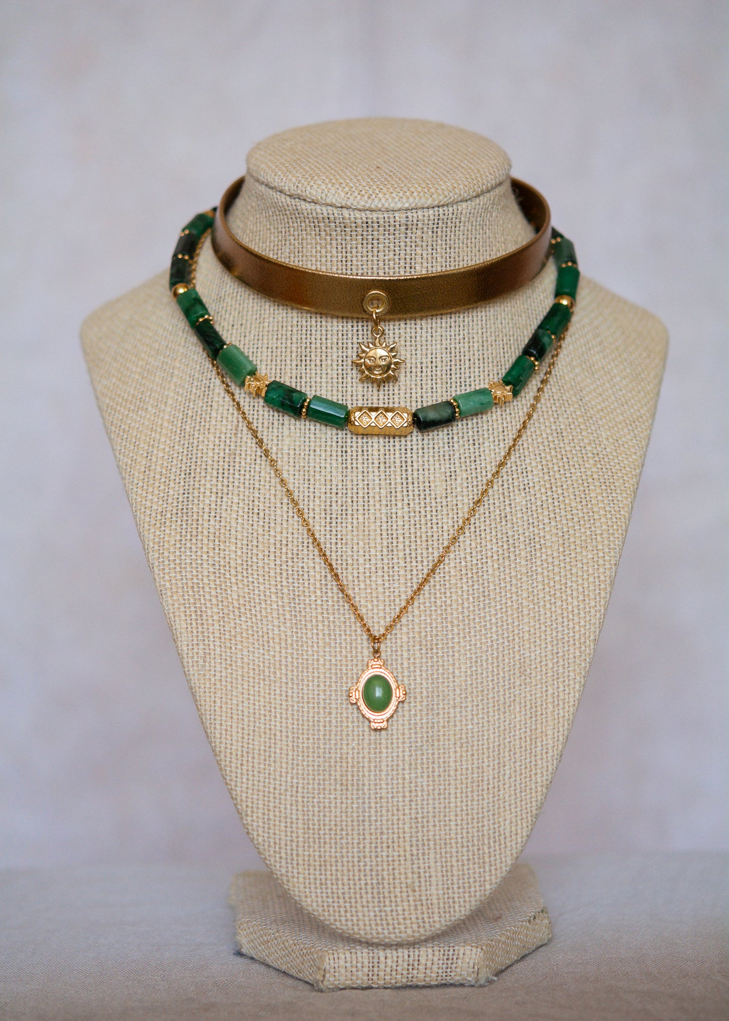 Ras de cou mystique avec cuir doré, émeraude brute, aventurine et breloque soleil. Look witchy boho, parfait pour festival ou tenue rituelle.