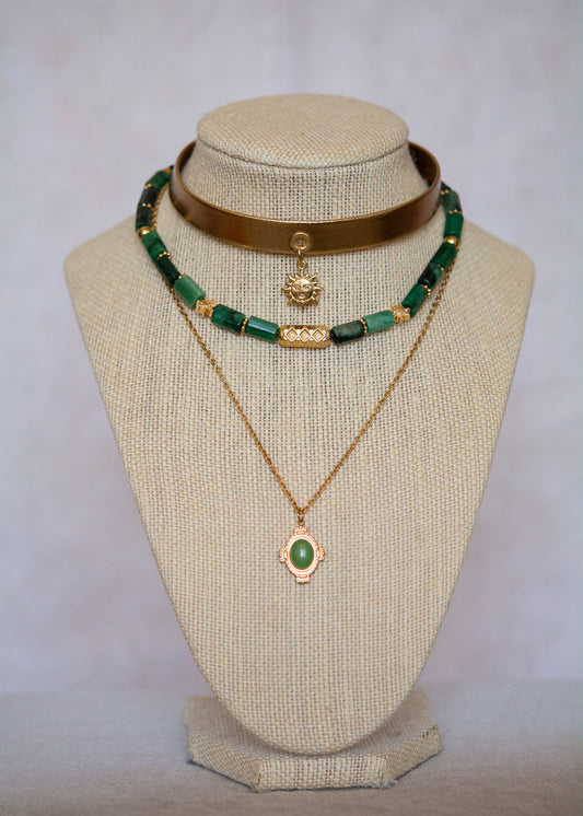 Ras de cou mystique avec cuir doré, émeraude brute, aventurine et breloque soleil. Look witchy boho, parfait pour festival ou tenue rituelle.