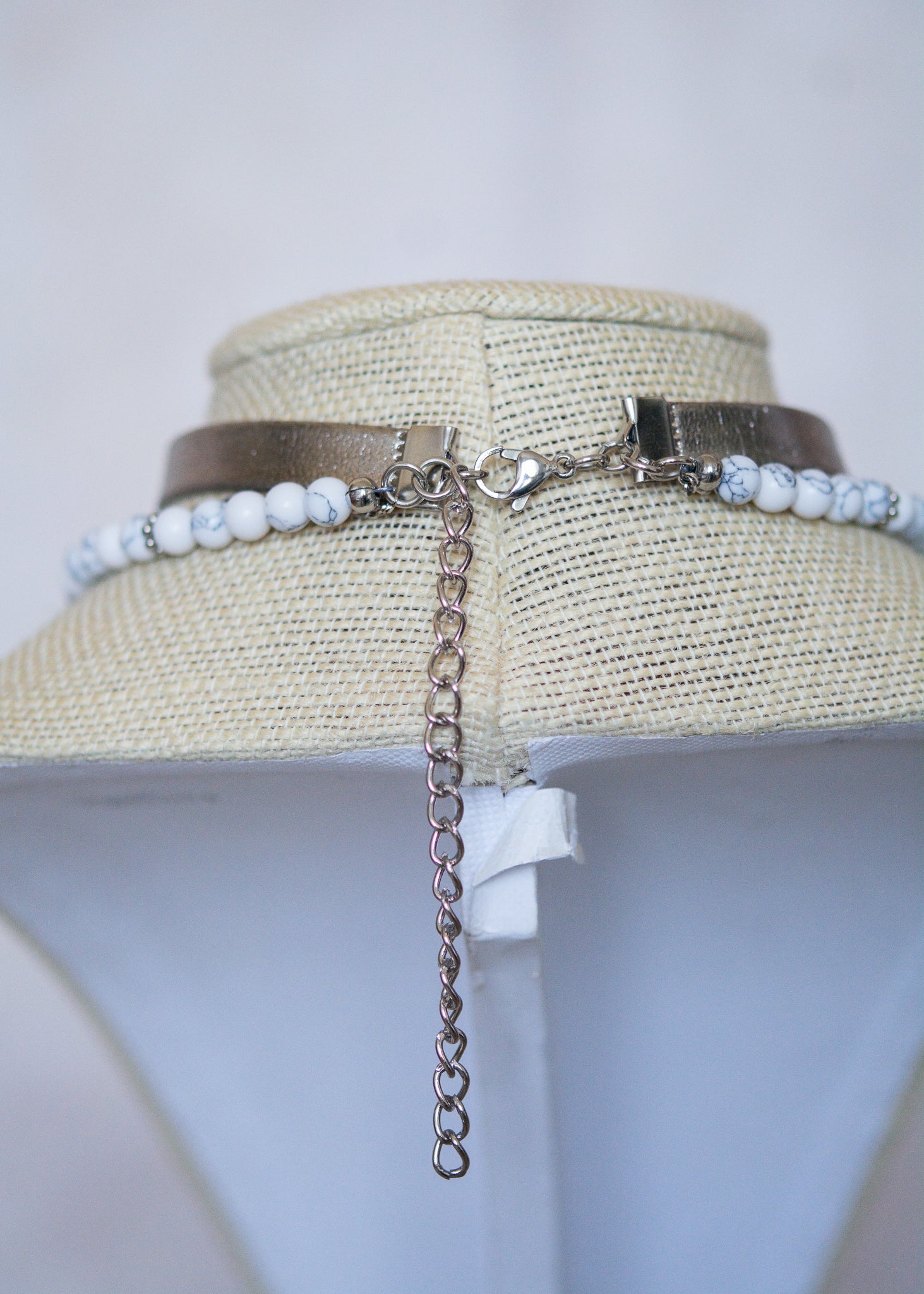 Collier argenté multi-rangs avec howlite blanche, cuir vegan et pendentif lune. Bijou astral, look witchy ou festival céleste.