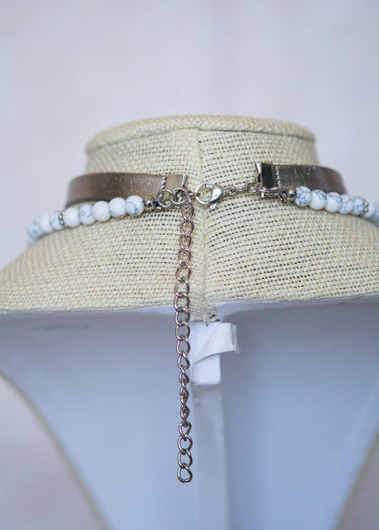 Collier argenté multi-rangs avec howlite blanche, cuir vegan et pendentif lune. Bijou astral, look witchy ou festival céleste.