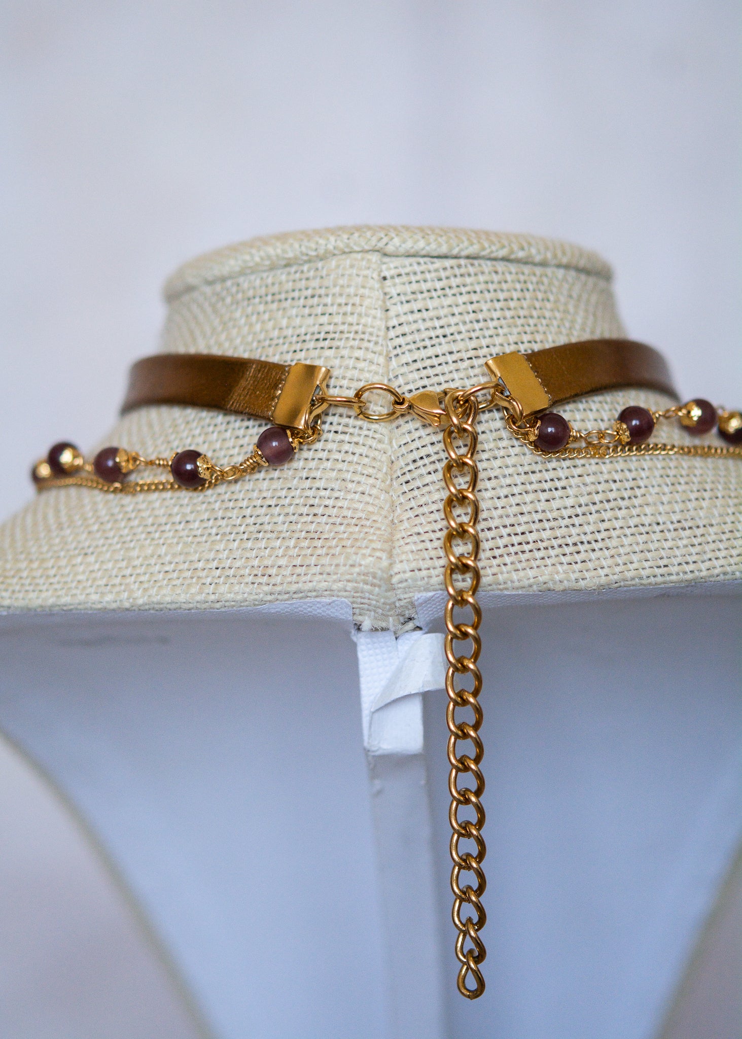 Tour de cou en cuir doré avec soleil mystique, améthyste et perles œil de chat. Bijou oraculaire d’inspiration antique et ésotérique.