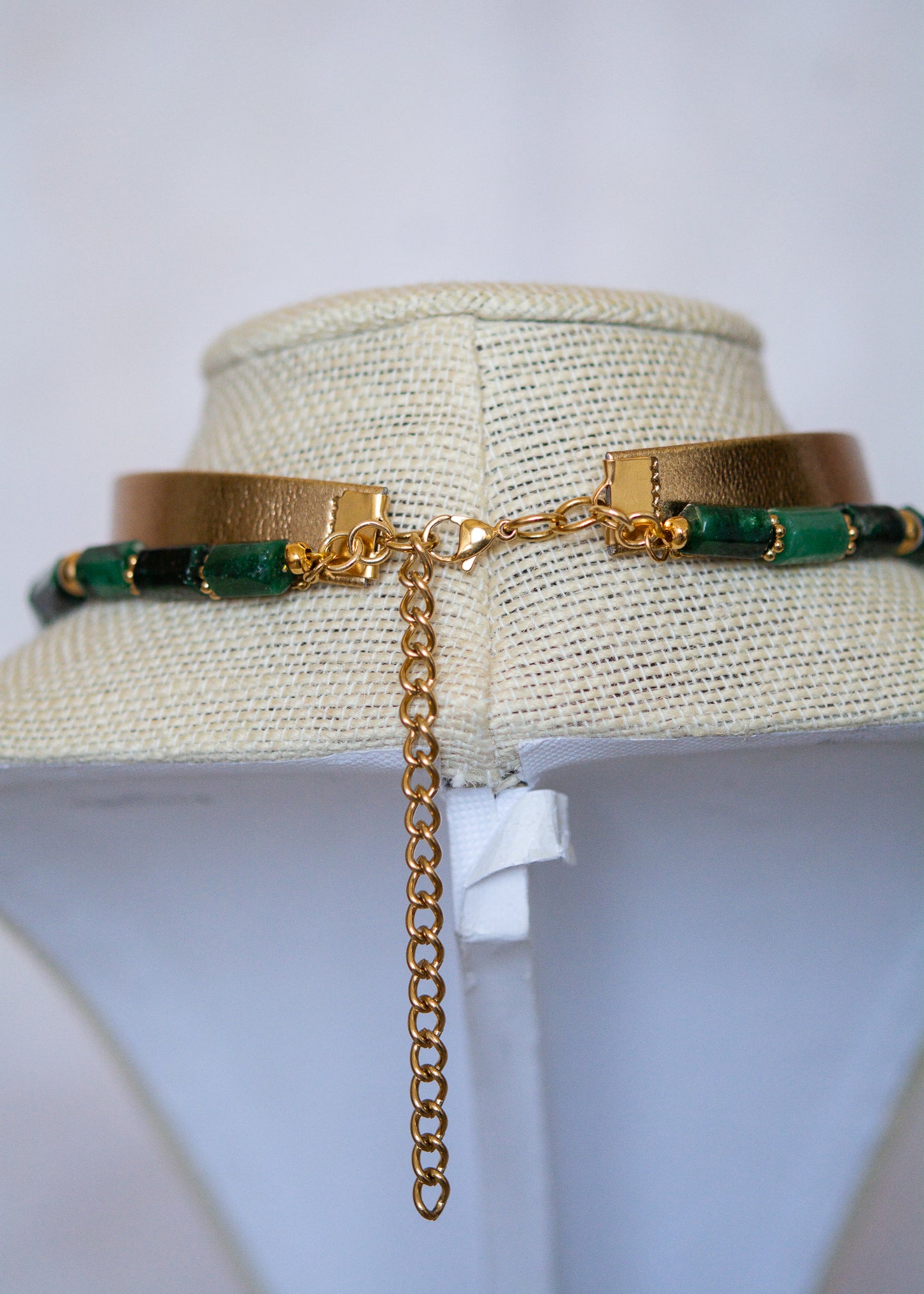 Ras de cou mystique avec cuir doré, émeraude brute, aventurine et breloque soleil. Look witchy boho, parfait pour festival ou tenue rituelle.