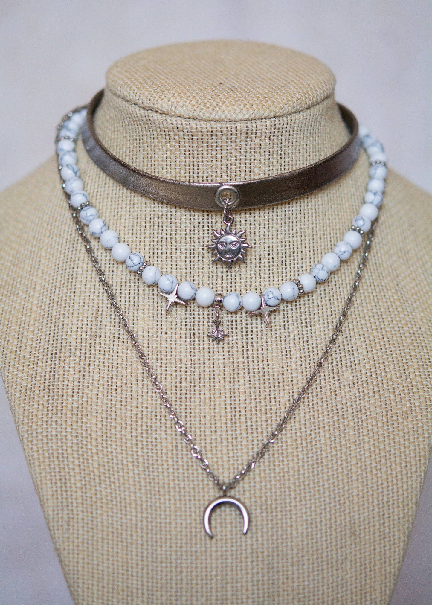 Collier argenté multi-rangs avec howlite blanche, cuir vegan et pendentif lune. Bijou astral, look witchy ou festival céleste.