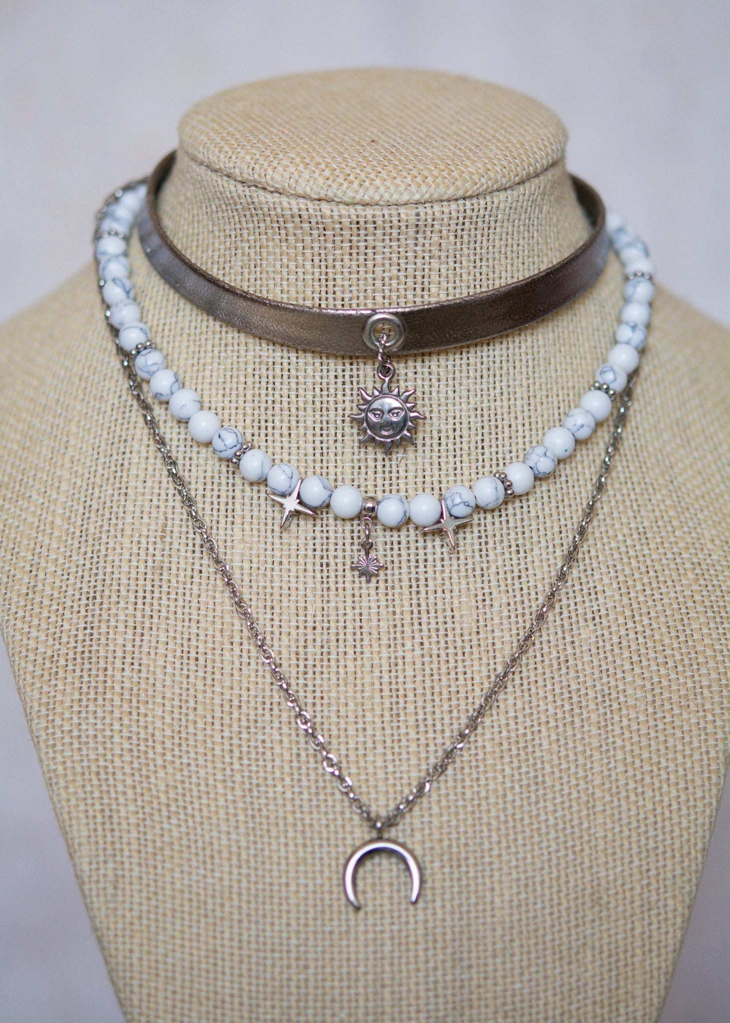 Collier argenté multi-rangs avec howlite blanche, cuir vegan et pendentif lune. Bijou astral, look witchy ou festival céleste.
