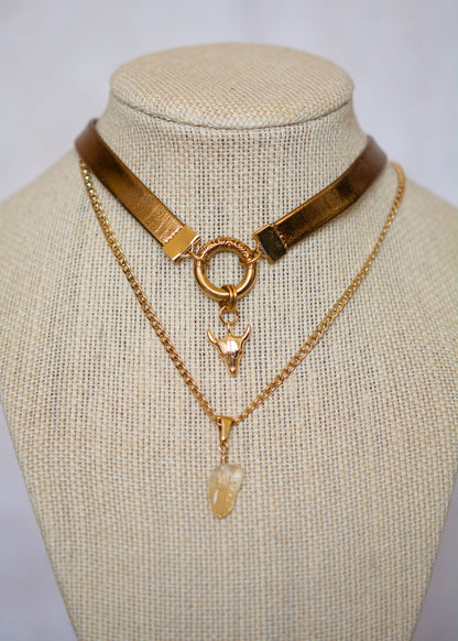 Tour de cou totem cuir doré avec crâne cornu, anneau gravé et citrine. Talisman mystique aux influences chamaniques et tribales.