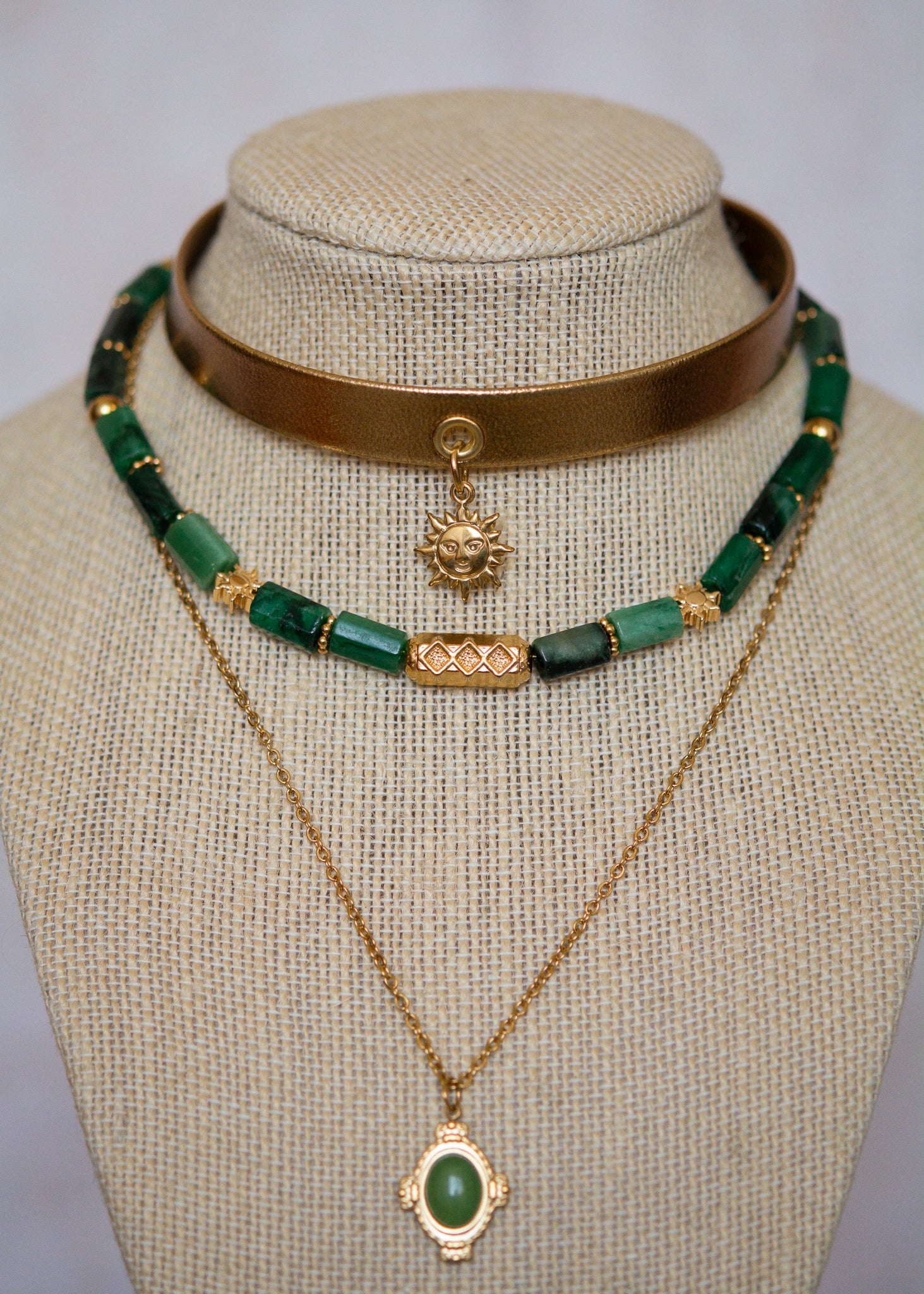 Ras de cou mystique avec cuir doré, émeraude brute, aventurine et breloque soleil. Look witchy boho, parfait pour festival ou tenue rituelle.