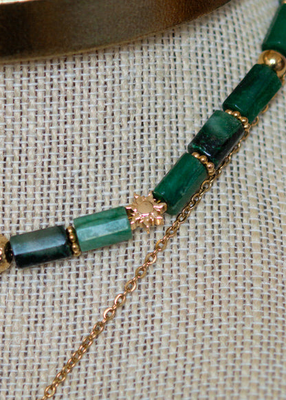 Ras de cou mystique avec cuir doré, émeraude brute, aventurine et breloque soleil. Look witchy boho, parfait pour festival ou tenue rituelle.