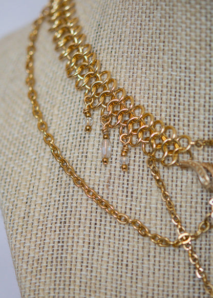 Collier doré elfique en chaîne côte de maille, broche vintage upcyclée et perles translucides. Bijou mystique, inspiré des légendes anciennes.
