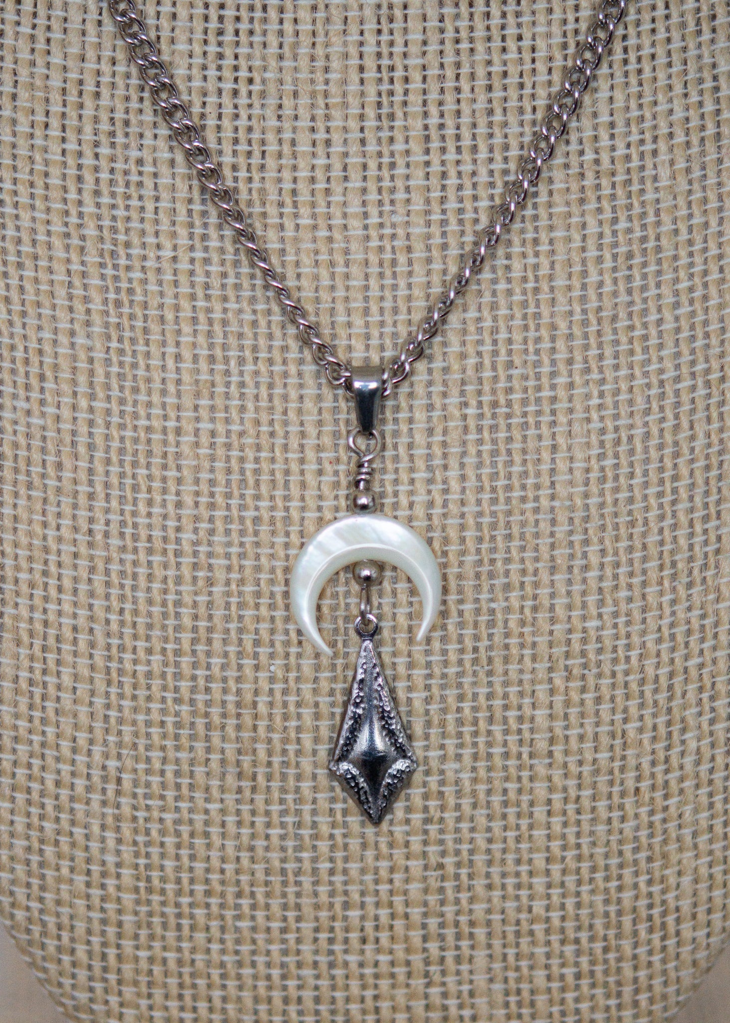 Collier en acier avec perles d'eau douce teintées rouge sang, piques, lune nacrée et charme mystique. Bijou rituel gothique, puissant et ensorcelant.