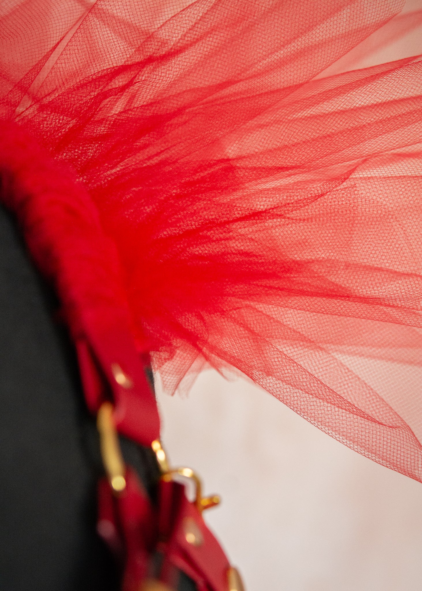 Harnais d'épaules audacieux en vinyle rouge végane avec épaulettes aériennes en tulle rouge et chaînes dorées amovibles. Cette pièce statement transforme instantanément votre silhouette en une célébration de force et de mystère, parfaite pour les festivals, soirées ou pour réinventer vos tenues quotidiennes avec une touche de magie guerrière.