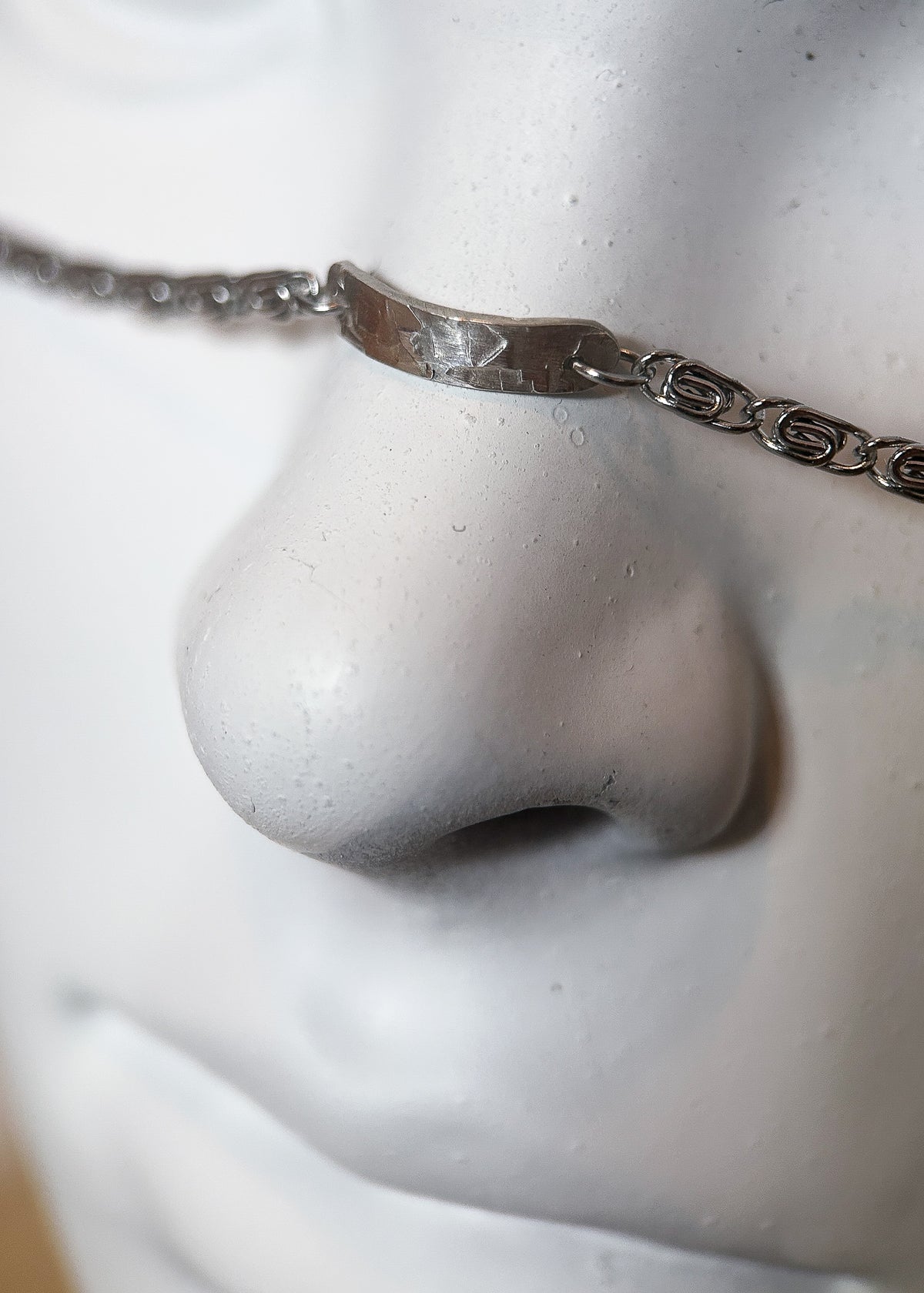 Chaîne de visage en acier inox avec pièce sur le nez en argent sterling 925 martelé, breloque plume, fait main à Montréal. Bijou facial idéal pour festival, photoshoot.