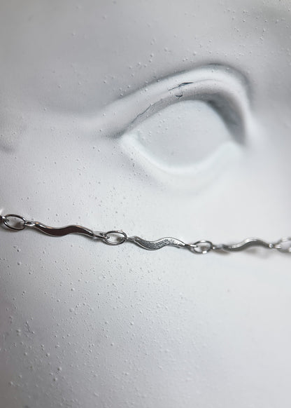 Bijou facial acier inoxydable, breloque plume, fait main à Montréal. Chaîne de visage boho pour festival, costume ou séance photo.