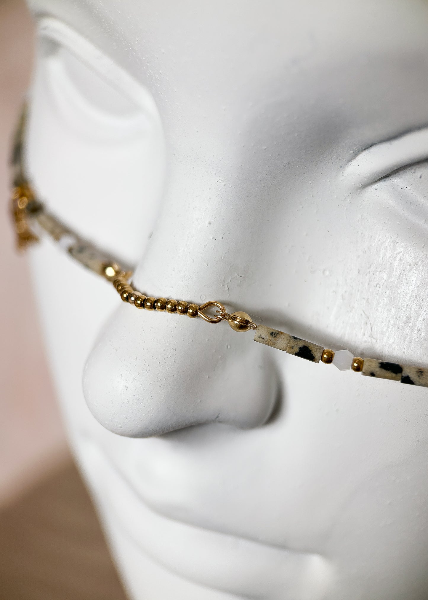 Chaîne de visage en jaspe dalmatien et pyrite sur acier inoxydable plaqué or, charms faucons. Bijou facial d'inspiration égyptienne fait main à Montréal.