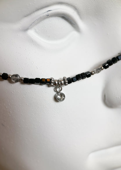 Chaîne de visage en spinelle noire et quartz rutilé sur acier inoxydable. Pièce unique alternative faite main à Montréal, parfaite pour festival et photoshoot.