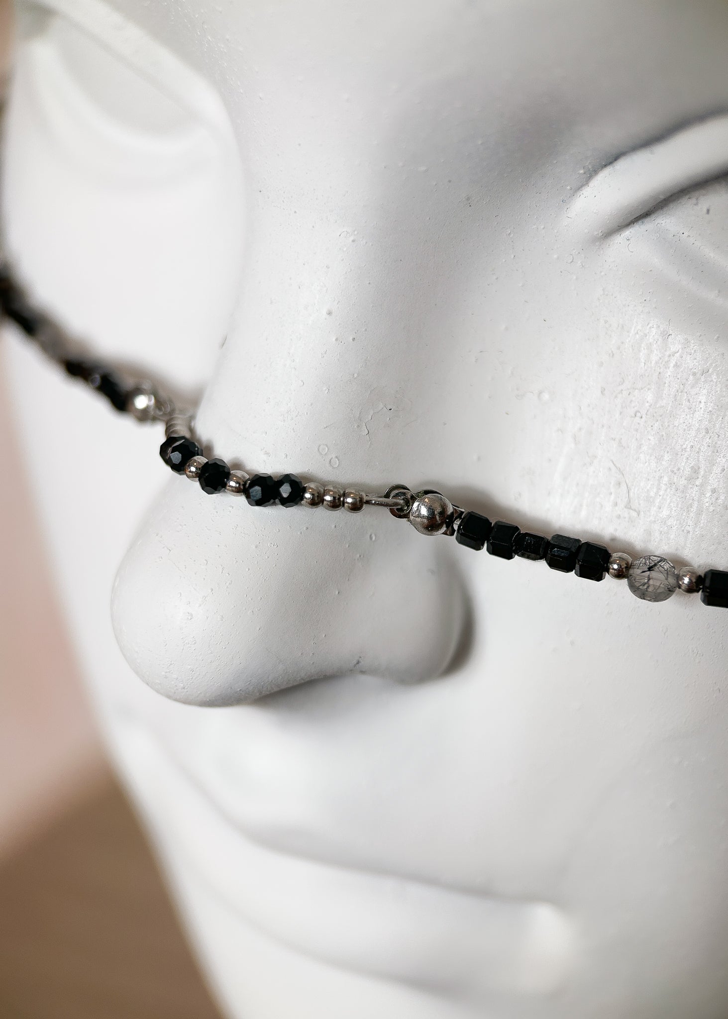 Chaîne de visage en spinelle noire et quartz rutilé sur acier inoxydable. Pièce unique alternative faite main à Montréal, parfaite pour festival et photoshoot.