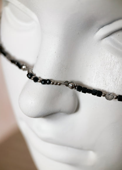 Chaîne de visage en spinelle noire et quartz rutilé sur acier inoxydable. Pièce unique alternative faite main à Montréal, parfaite pour festival et photoshoot.