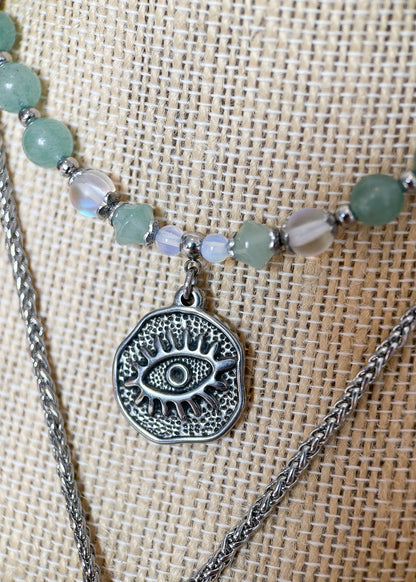 Collier double rang en acier inoxydable avec aventurine et pierre de lune, pendentif œil protecteur. Pièce unique faite main à Montréal, style bohème.