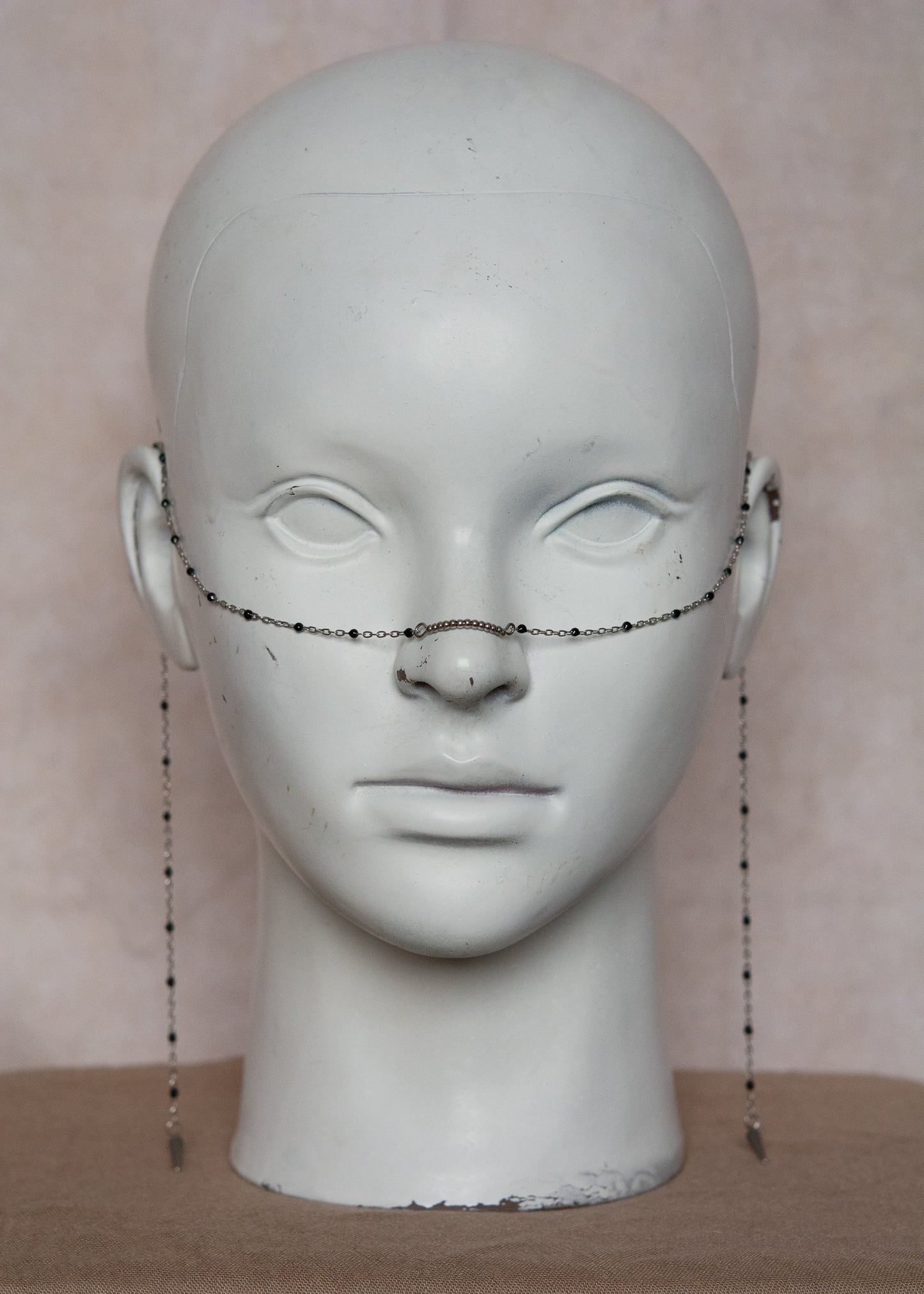 Bijou facial en chaîne fine avec perles d’émail noir et piques. Accessoire sombre et délicat pour look alternatif minimaliste.