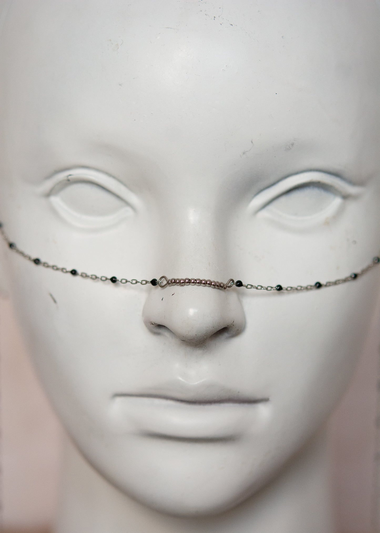 Bijou facial en chaîne fine avec perles d’émail noir et piques. Accessoire sombre et délicat pour look alternatif minimaliste.