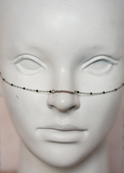 Bijou facial en chaîne fine avec perles d’émail noir et piques. Accessoire sombre et délicat pour look alternatif minimaliste.