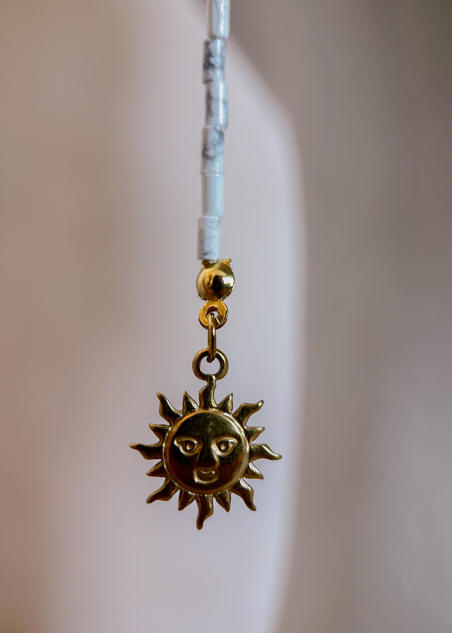 Bijou facial acier inoxydable doré, œil de tigre et howlite blanche avec détails soleil. Accessoire solaire et mystique, parfait pour festival ou événement.