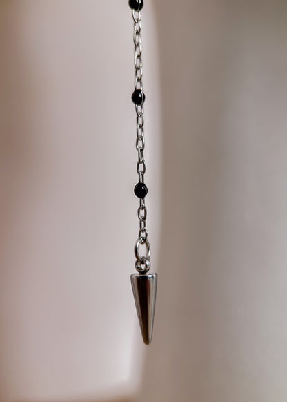 Bijou facial en chaîne fine avec perles d’émail noir et piques. Accessoire sombre et délicat pour look alternatif minimaliste.