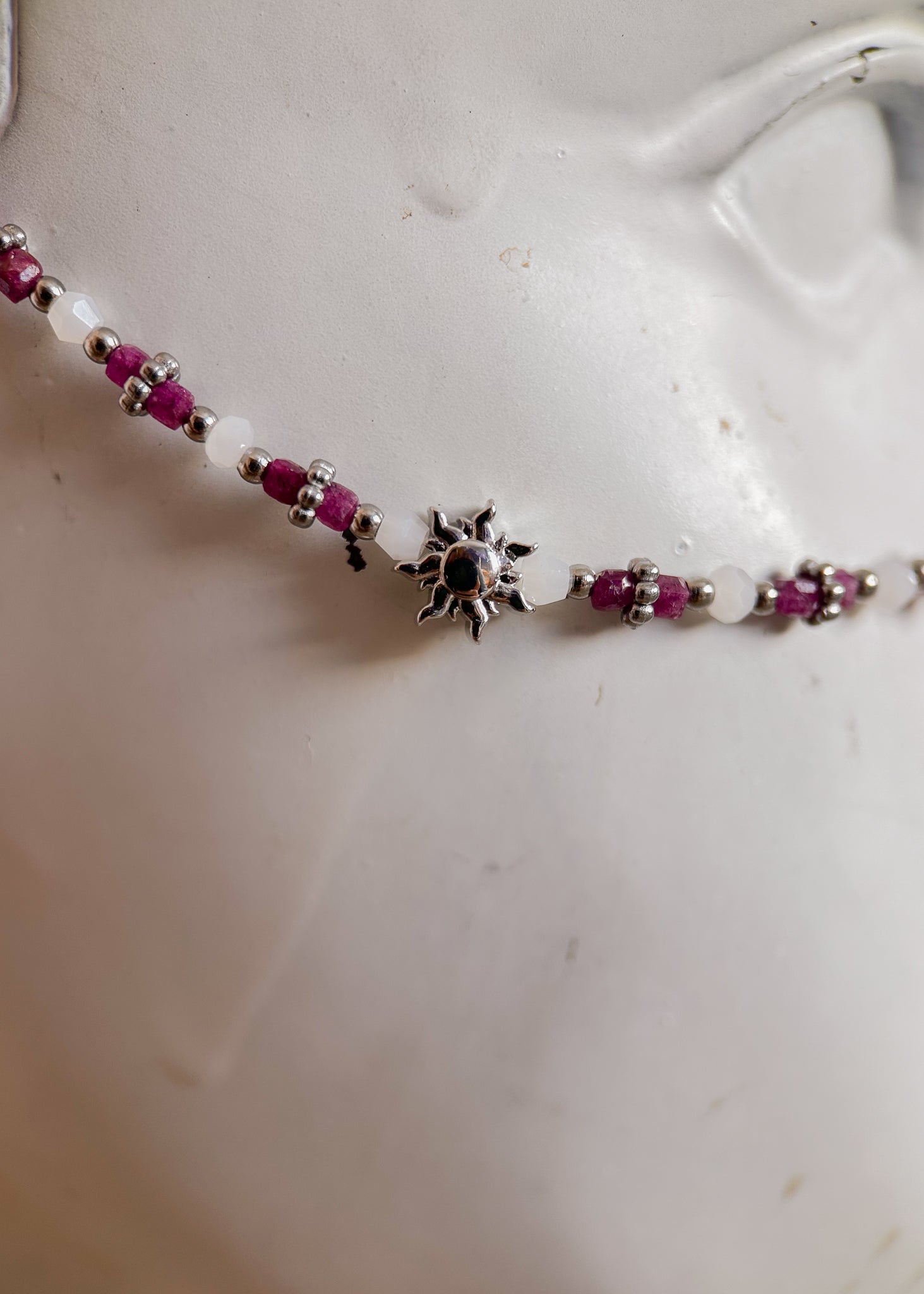 Bijou facial en rubis non raffiné et acier inoxydable avec soleils argentés. Accessoire solaire pour look boho tribal, rituel ou festival.